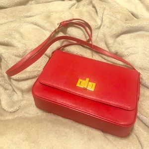 A Cross body bag in red .